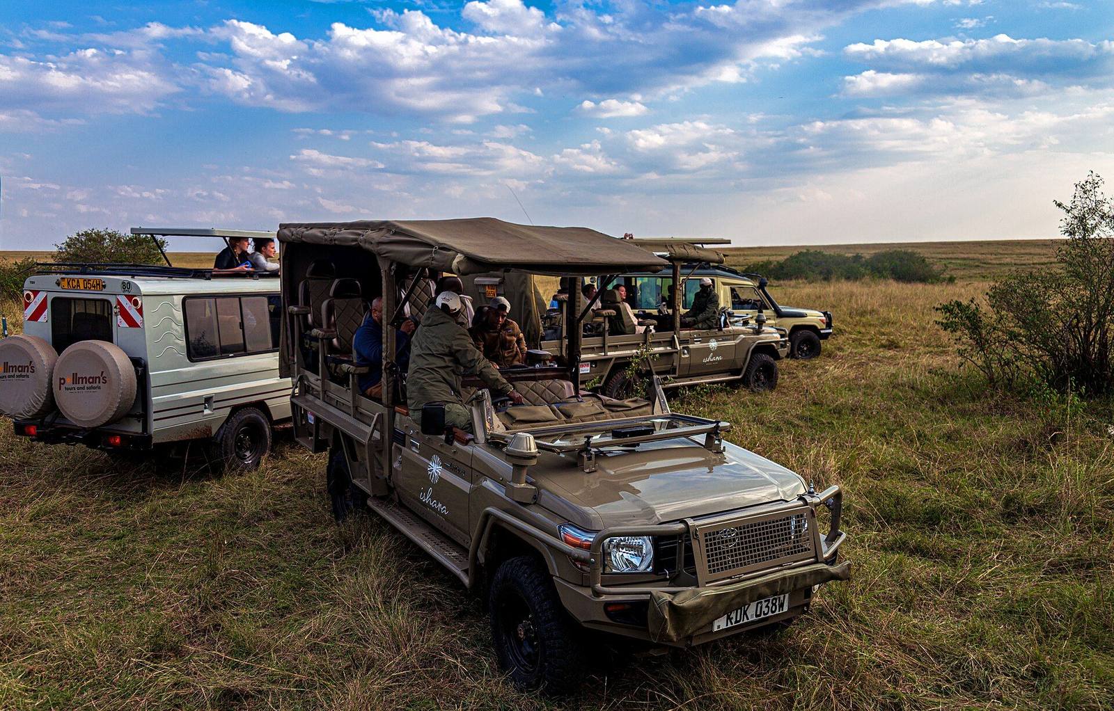 Safari vehicles watching lions in the Masai Mara
